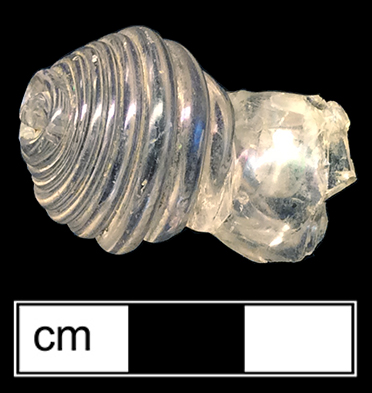 Colorless soda lime knob to unknown vessel form.  Horizontal ribs.  Blown in mold (McKearin and McKearin 1989:272). 18BC27-F30